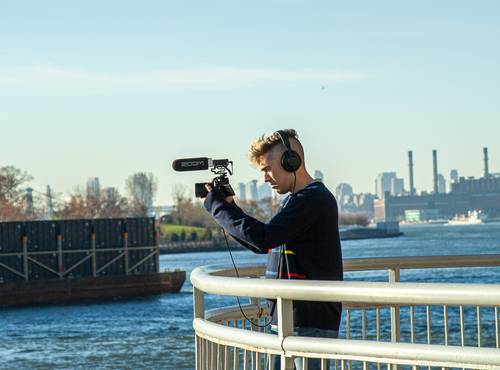 videographer recording with F1-SP mounted on a DSLR camera under the 59th Street bridge, New York City