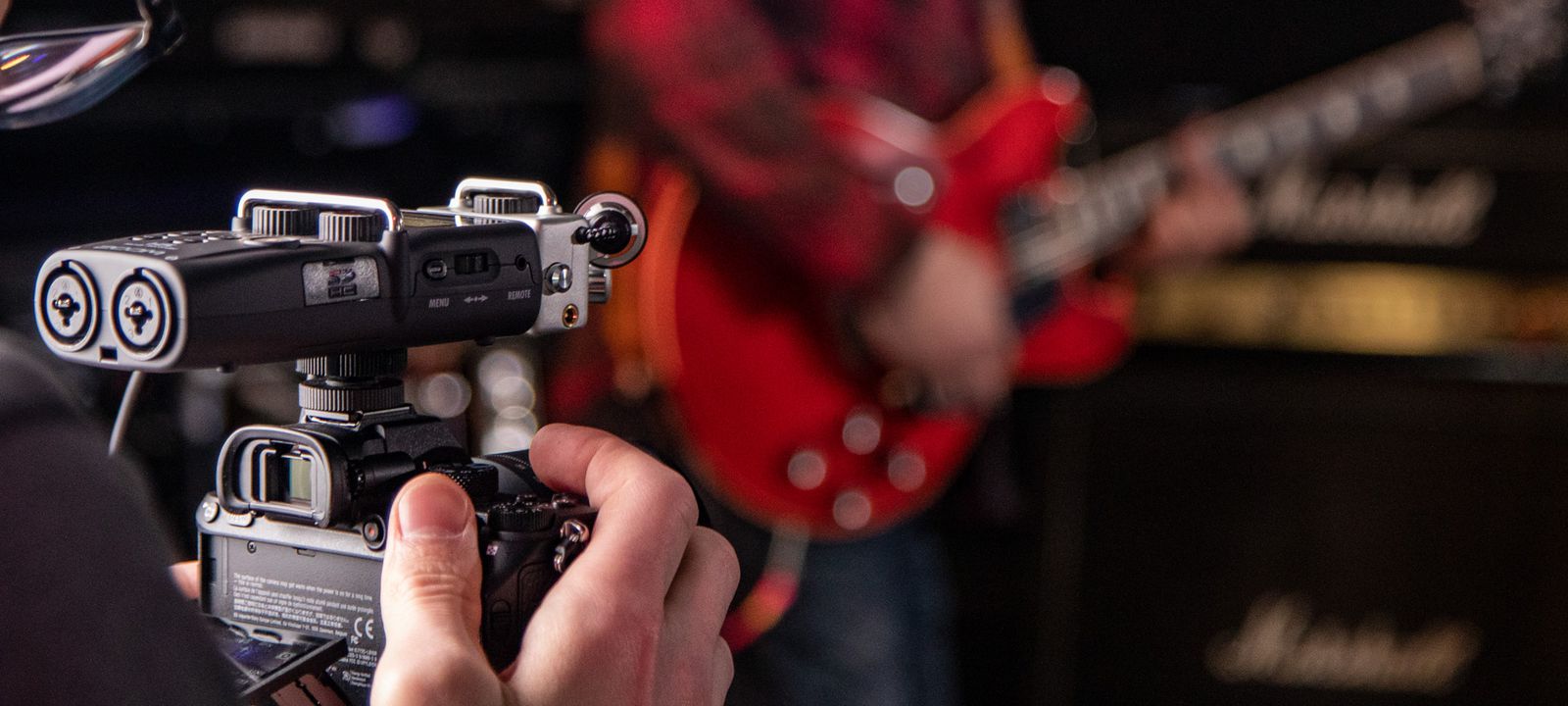 Videographer recording musician with H5 mounted to DSLR camera