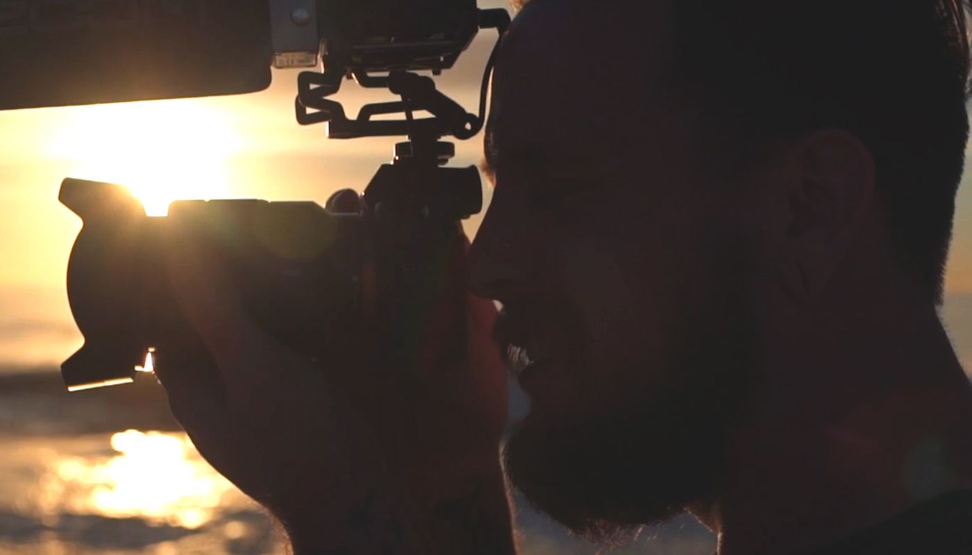 videographer on beach with sun setting using DSLR camera with F1-SP attached