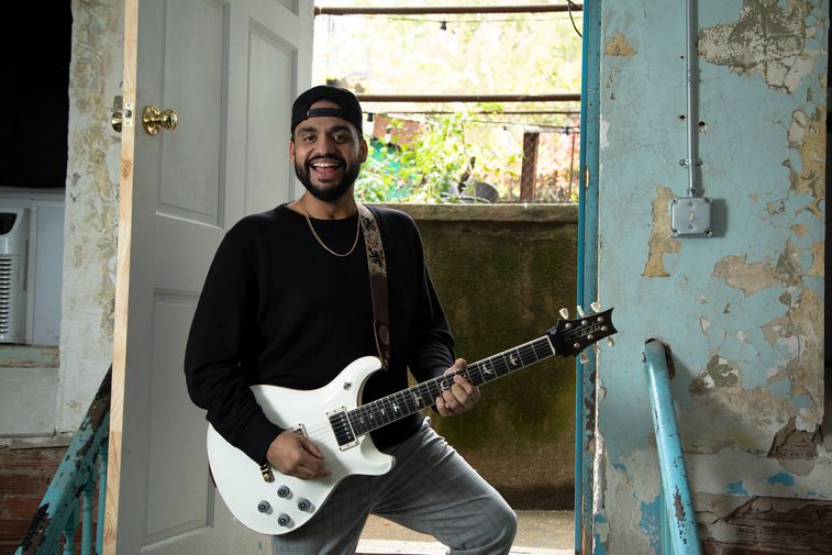 Ricardo Ramos standing on the stairs with his guitar