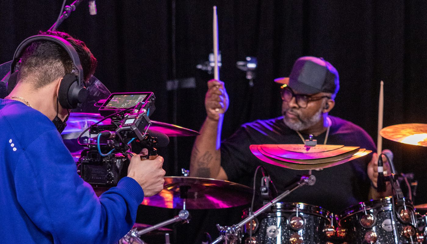 Videographer filming a drummer in the studio