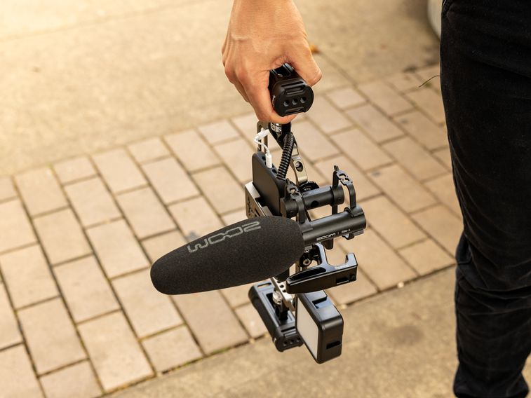 videographer holding a mobile phone camera rig with the ZSG-1 attached