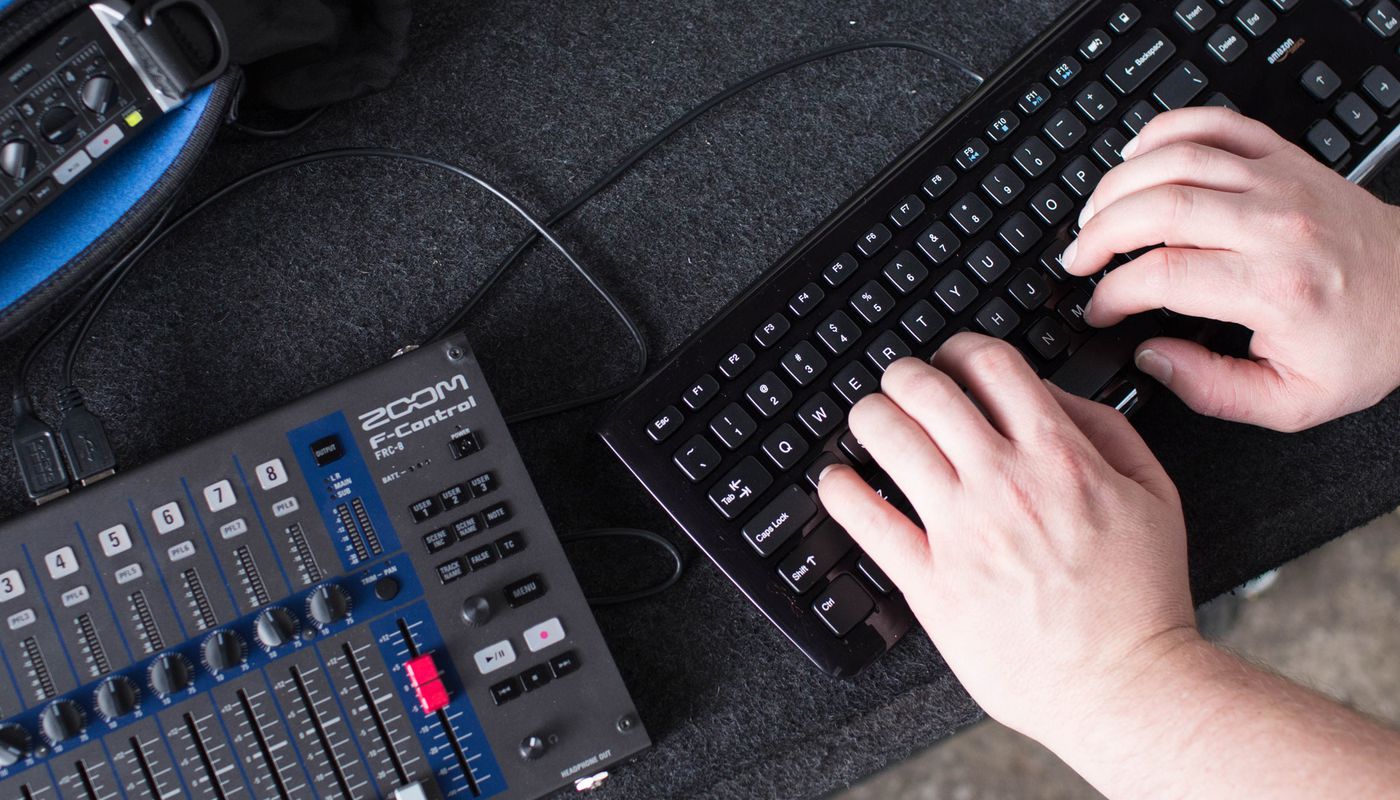 Location sound engineer using a keyboard to input track metadata.