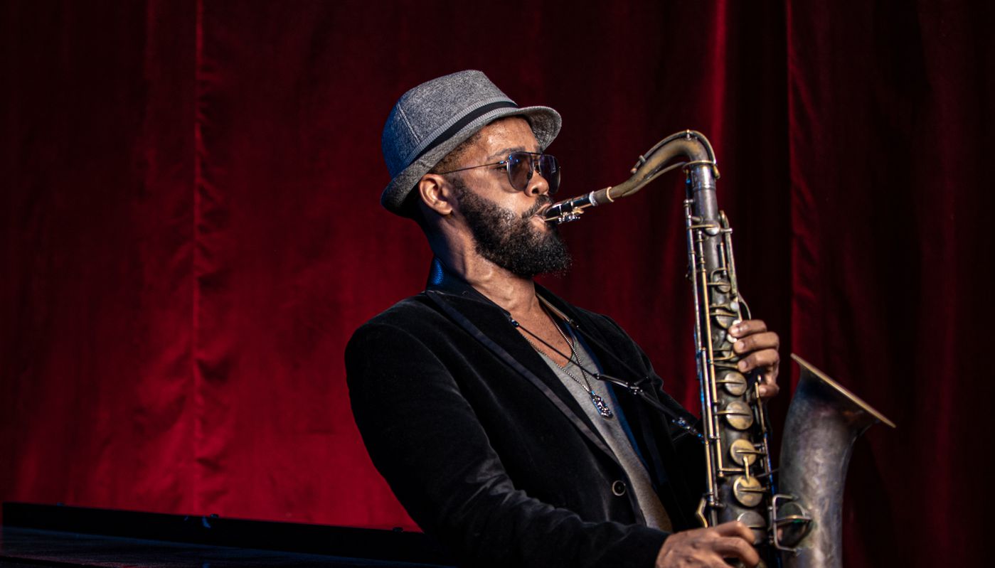 The coolest of cool cats playing the saxophone with hat